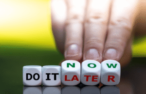Estate Tax Changes Coming in 2026: What High-Net-Worth Individuals Must Do Now Hand placing blocks that spell 'DO IT LATER' with 'NOW' visible, conveying procrastination.