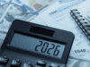 How to Buy a Dental Practice in 2026: Financial & Tax Guide for Dentists Close-up of a calculator on top of tax forms and scattered US dollar bills, with a spiral notebook nearby, suggesting accounting or budgeting.