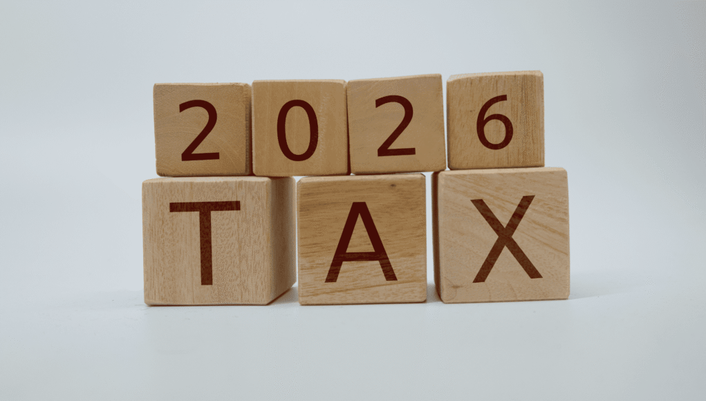 Blocks spell '2026 TAX' on a pale background, stacked in two rows.